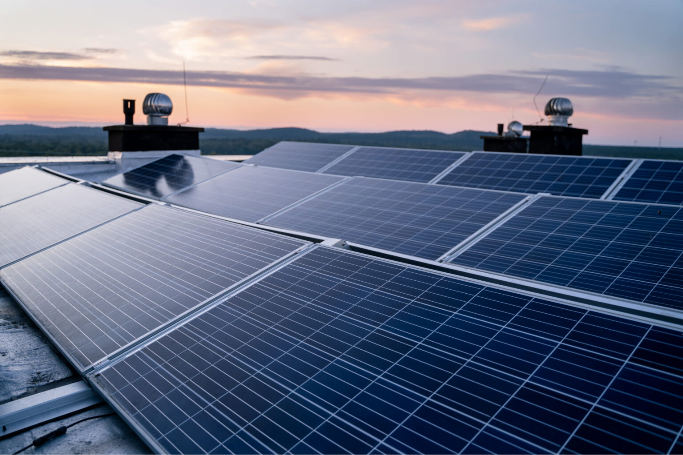 solar panels on a roof with sunset in background