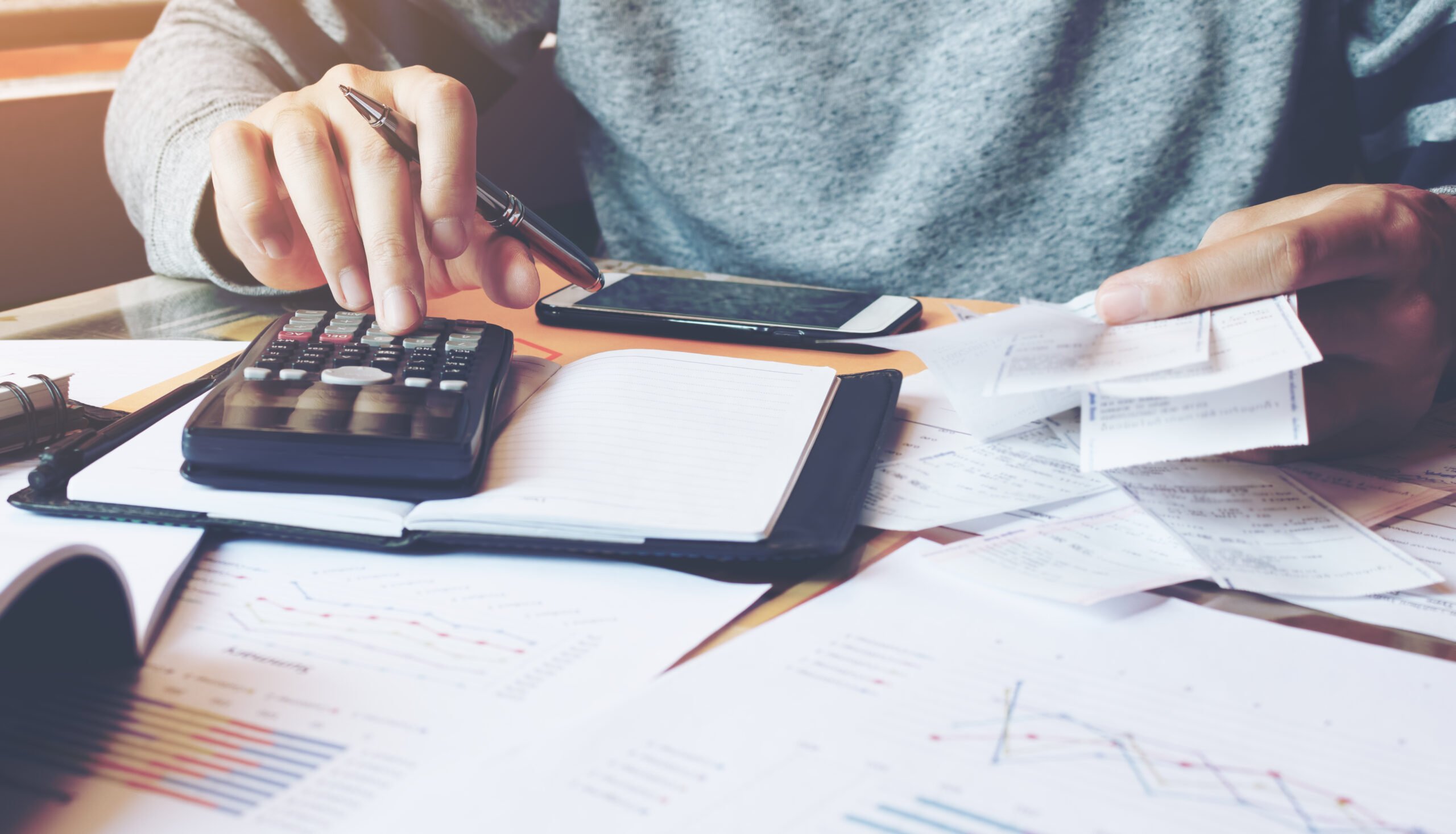 Man using calculator and billing receipts