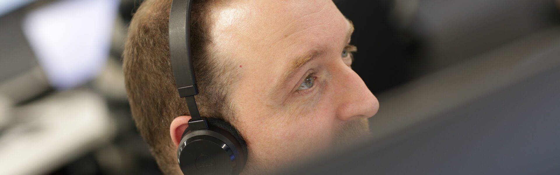 Worker with headset looks off camera