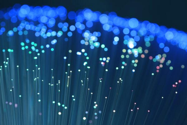 Feature image Close-up of fibre optic cables with bright blue, green and pink light points.