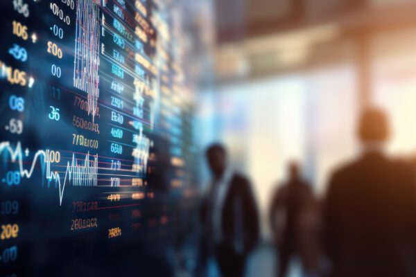 Blurred scene of people in a city looking at a digital stock market display, indicating real-time trading data with glowing numerical values.