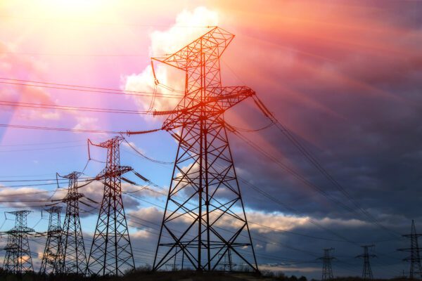 Feature image Pylons under a cloudy sky with sunlight breaking through